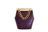 Bordeaux watersnake mini bucket bag featuring a gold-tone designer logo clasp and a luxurious chunky gold chain handle.
