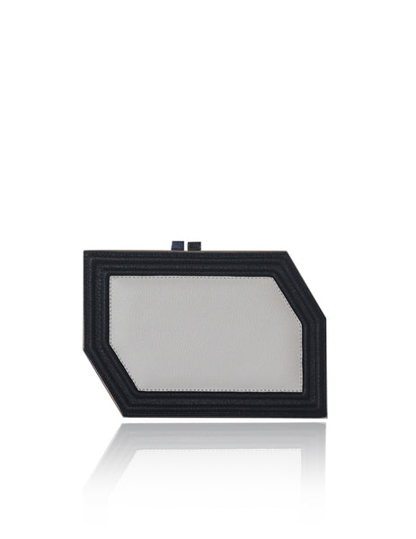Geometric Edith clutch in textured black and off-white calf leather with a sleek, modern box silhouette and gunmetal hardware.