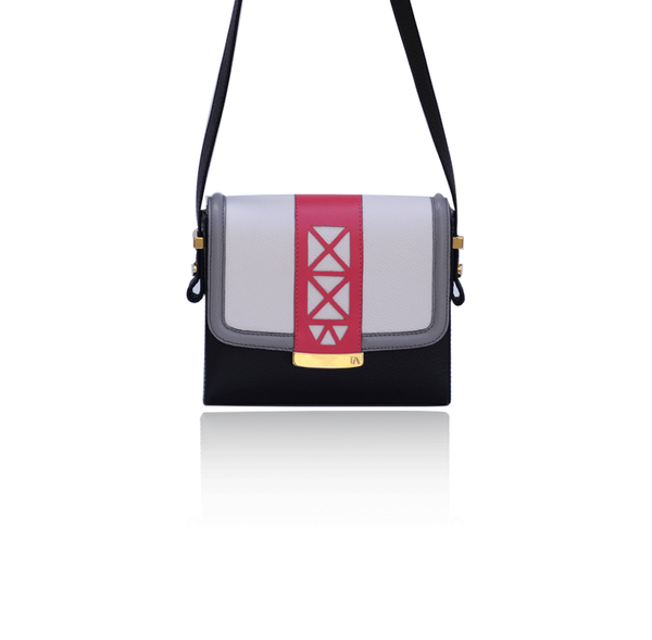 Anya crossbody bag in cream, black, and watermelon leather with gold hardware, laser-cut trim, and an adjustable strap.