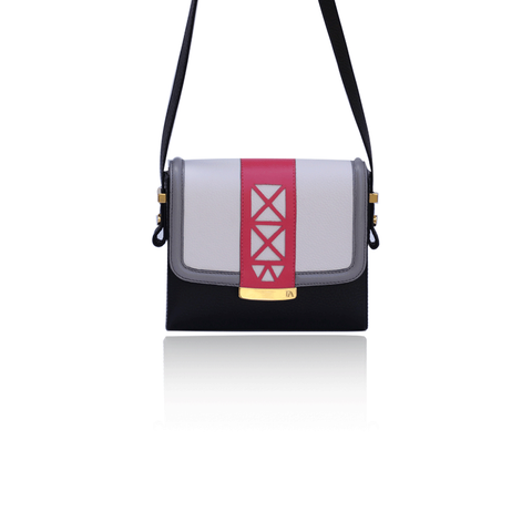 Anya crossbody bag in cream, black, and watermelon leather with gold hardware, laser-cut trim, and an adjustable strap.