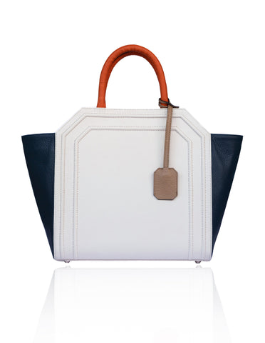 Cream and navy textured leather Sharon trapeze tote with papaya handles, nude hanging tag, and silver-tone hardware.