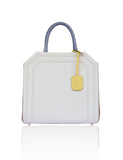 Structured cream and sand textured leather Sharon tote with teal handles, banana yellow tag, and gold-tone hardware.