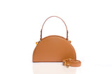 Tan grainy leather taco-shaped handbag with gold-tone hardware, an adjustable handle, and a detachable shoulder strap.