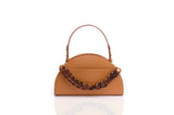 Tan grainy leather Jenna taco bag with a semi-circular shape, top handle, and decorative brown tortoiseshell chain detail.