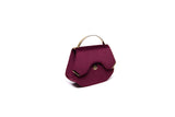 Wine red velvet Calypso top-handle bag featuring a structured silhouette, gold-tone hardware, and elegant designer logo.